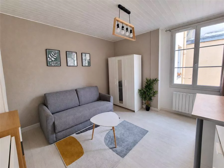 Studio rénové rue de Bouillé, canapé gris et plafond lambrissé