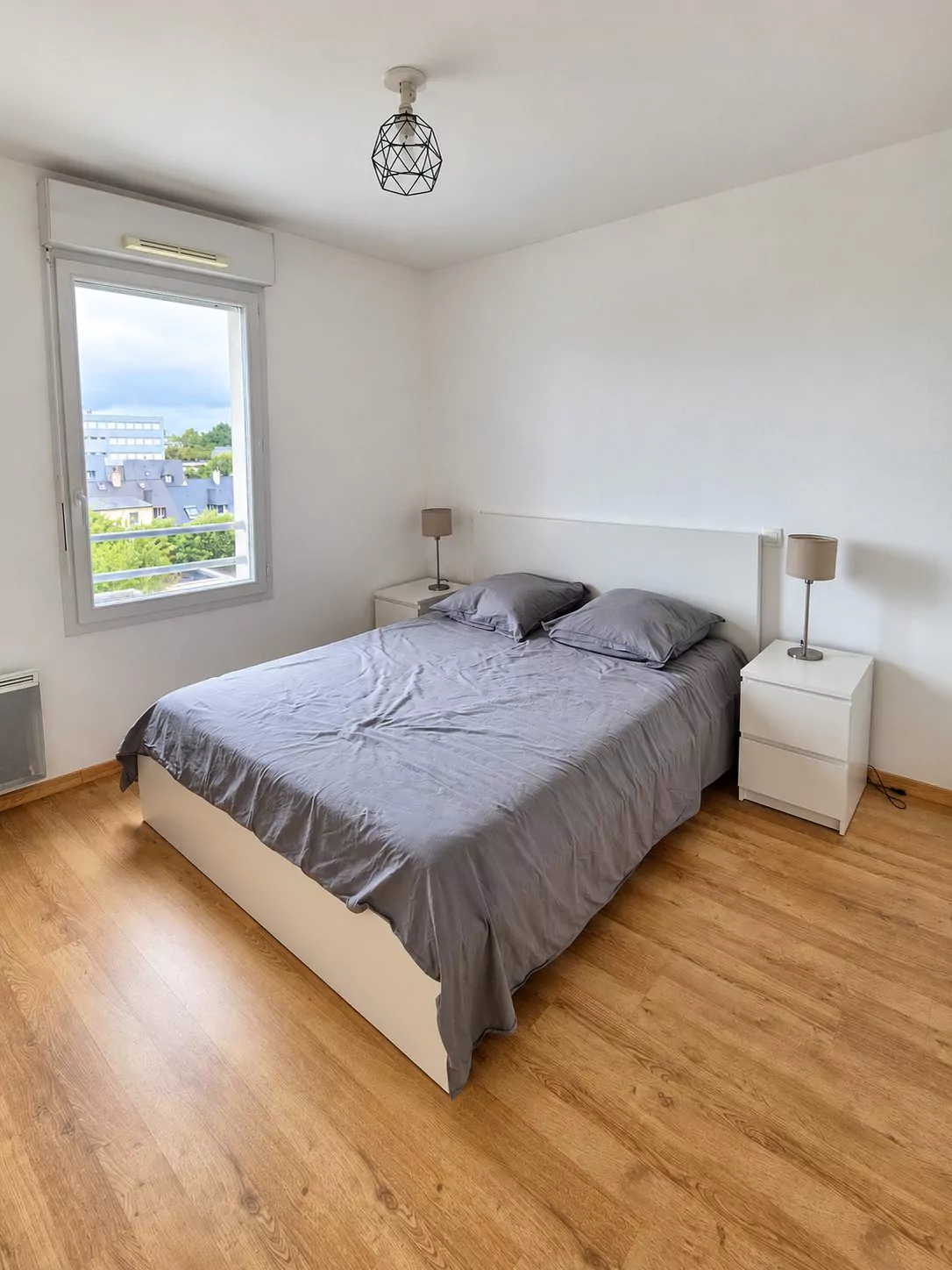 Chambre meublée, lit double gris et placard